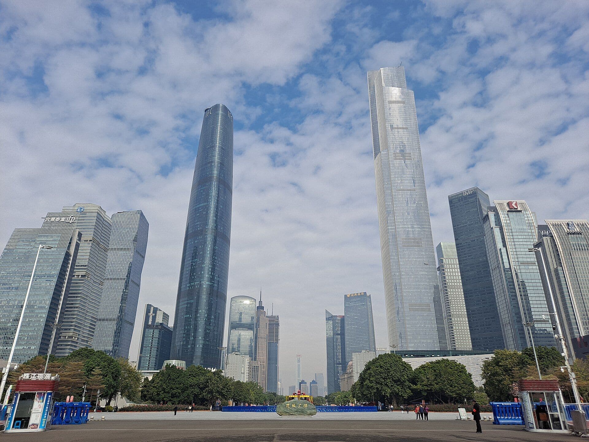 Glass skyscrapers of Zhujiang New Town, including the twin IFC and CTF towers, rise around Huacheng Square under a blue sky