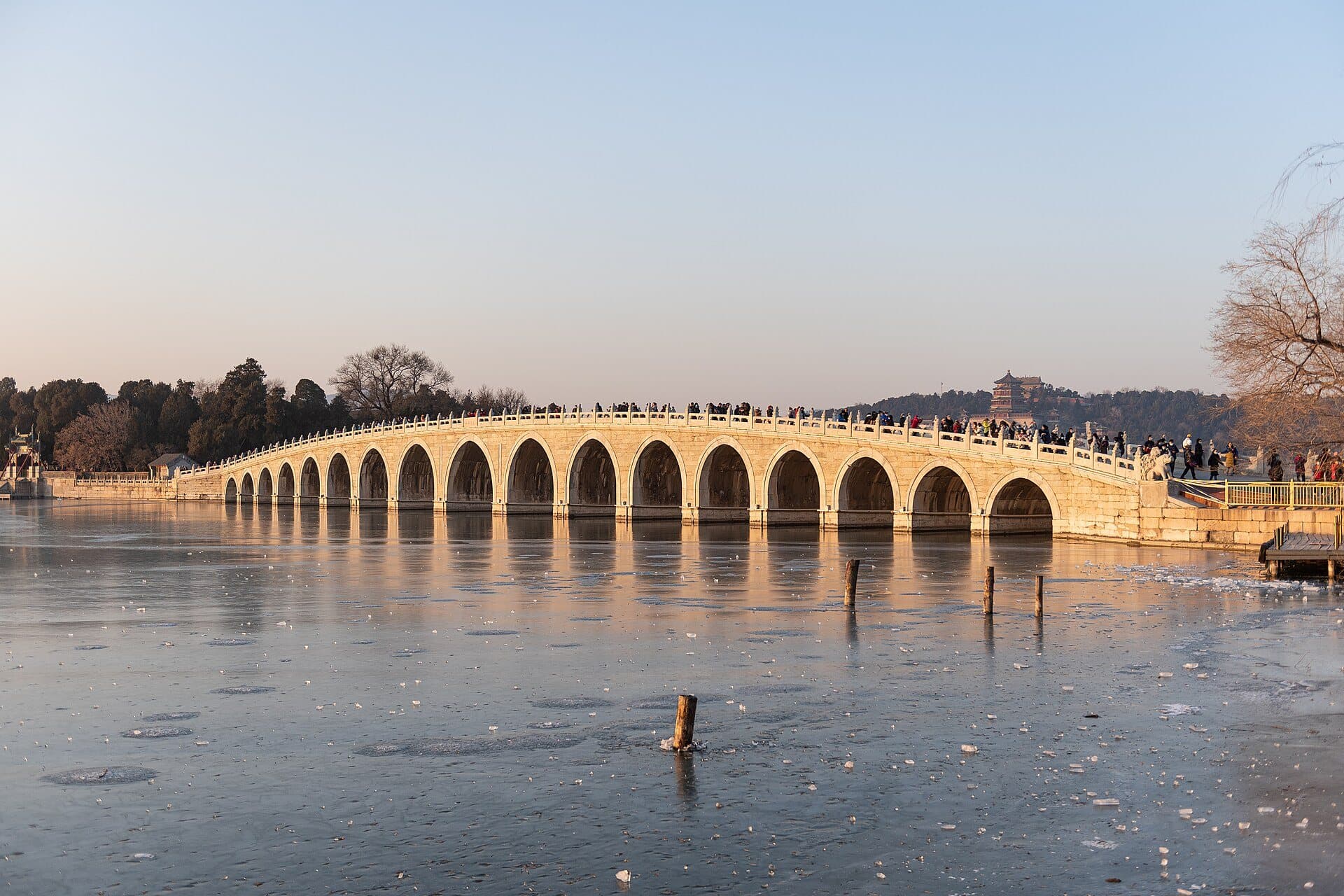 The Seventeen-Arch Bridge at the Summer Palace in late-afternoon winter light over frozen Kunming Lake